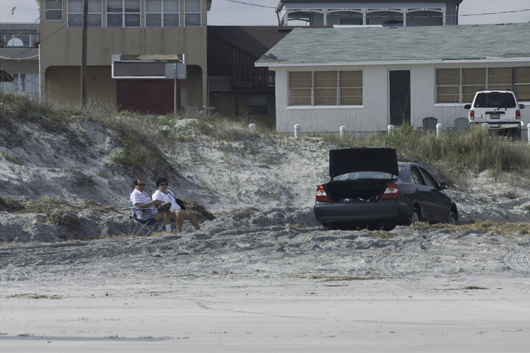 Mom and Dad seated by the immobilized Toyota